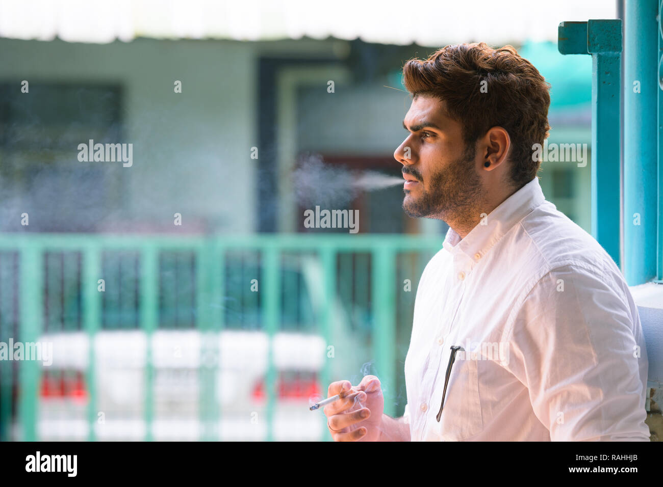Voir le profil de jeune homme indien barbu beau fumeurs à l'extérieur Banque D'Images