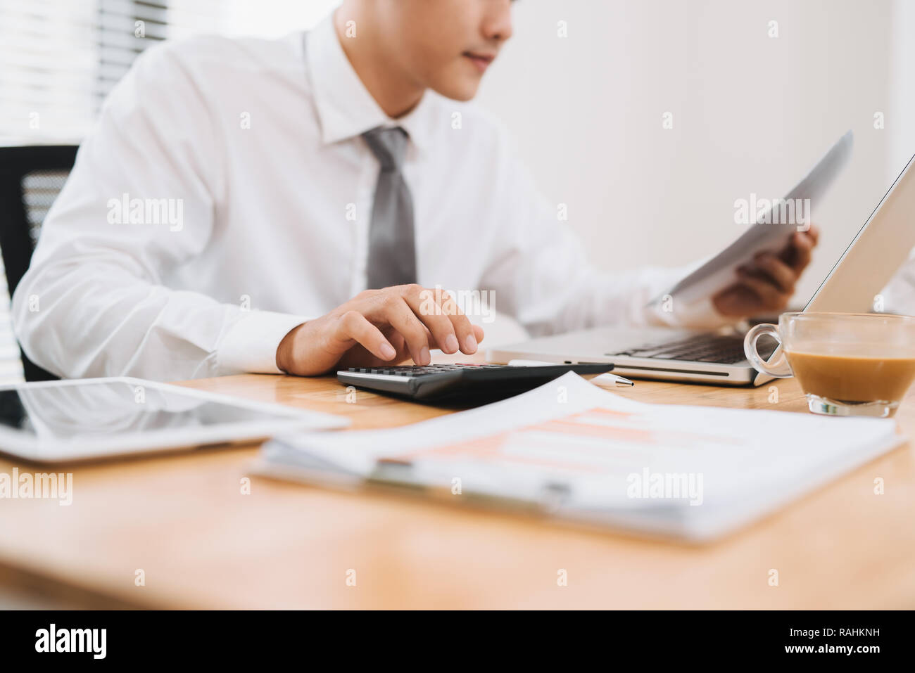 Business man holding paper, occupé à travailler sur ordinateur portable et utilisant calculer dans un bureau moderne, Close up. Concept de processus de travail Banque D'Images