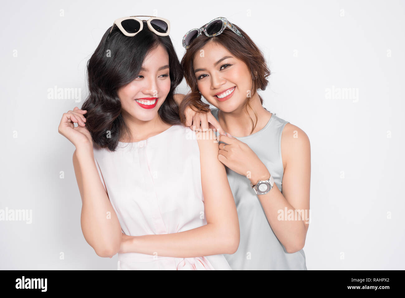 Image d'un jeune deux filles friends posing isolated over white wall habillé Banque D'Images