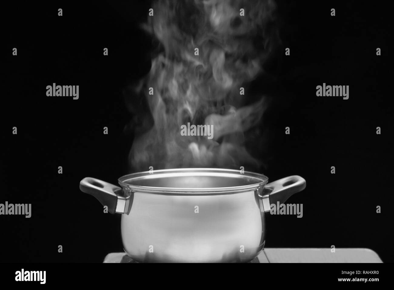 Plus de vapeur casserole en cuisine sur fond sombre Banque D'Images
