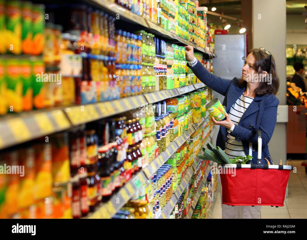 Achat femme de légumes en conserve dans un ministère d'épicerie libre-service, supermarché Banque D'Images