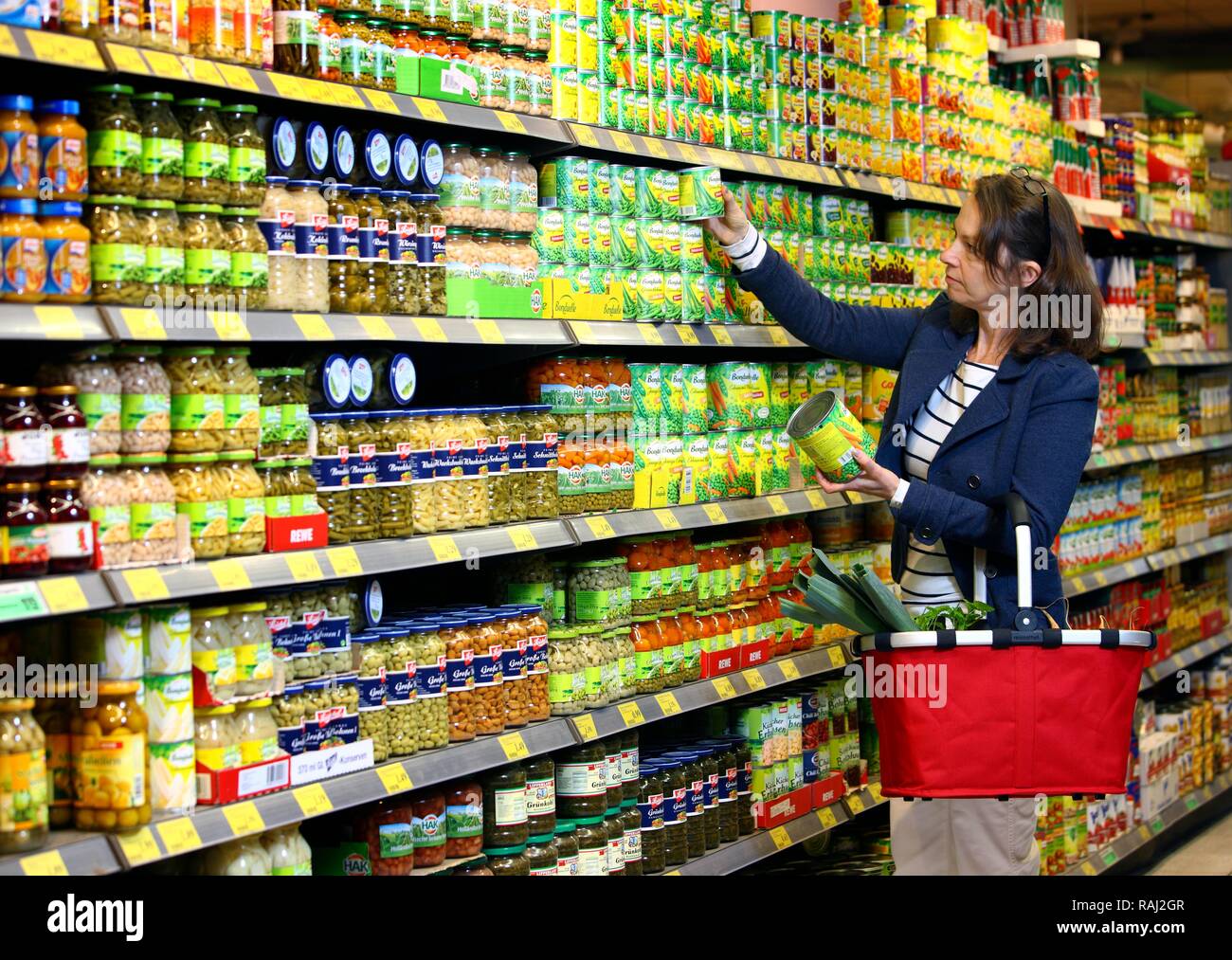 Achat femme de légumes en conserve dans un ministère d'épicerie libre-service, supermarché Banque D'Images