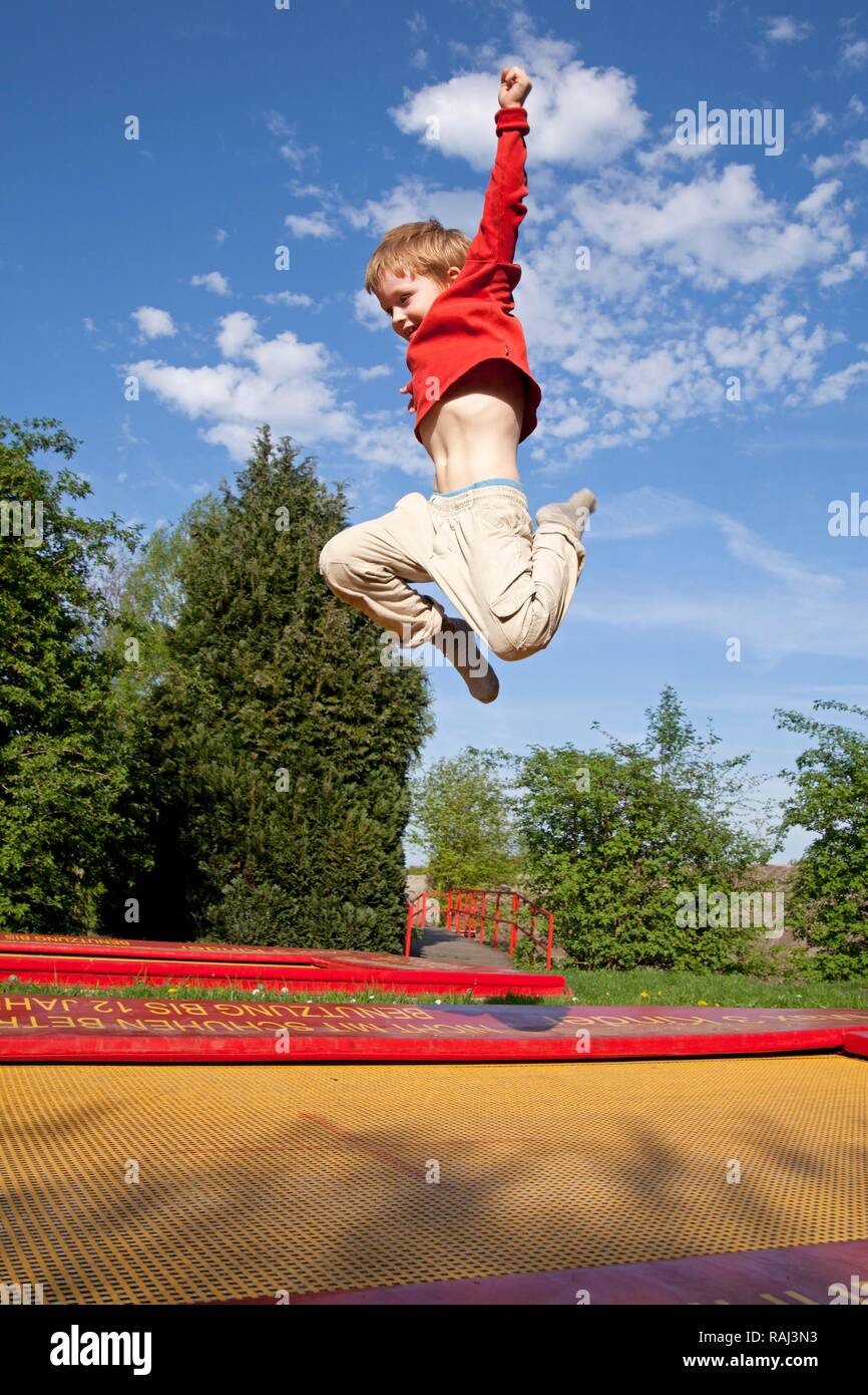 Garçon sautant sur un trampoline, Serengeti Park Zoo et parc de loisirs, Hodenhagen, Basse-Saxe Banque D'Images