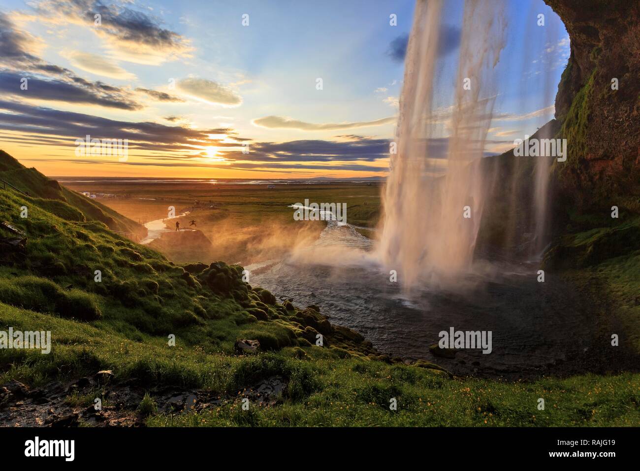 Seljalandsfoss au coucher du soleil, à côté de deux personnes, des silhouettes à la séance photo, Suðurland, Sudurland, près de ring road Banque D'Images