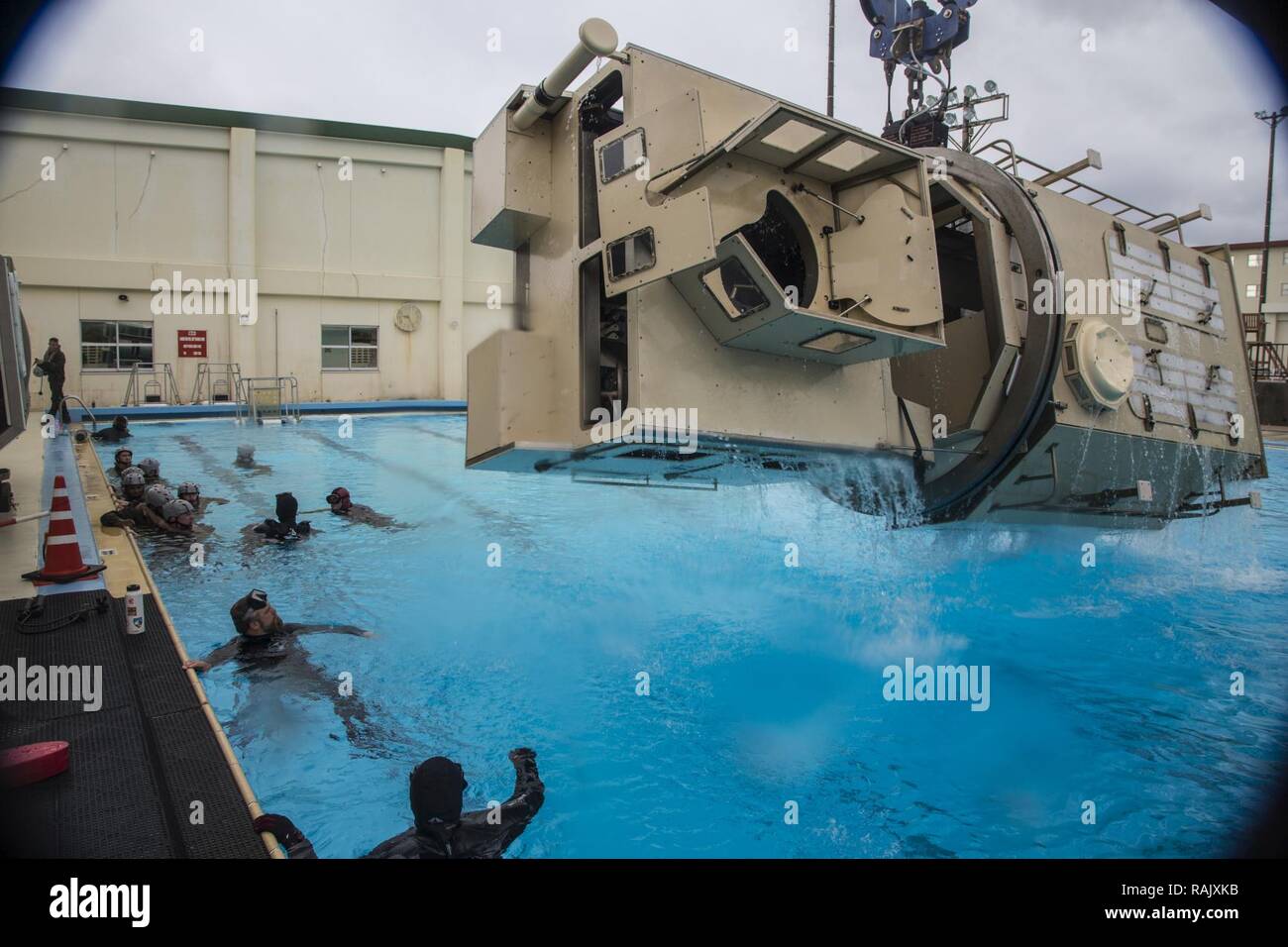 Les Marines américains avec Truck Company, 3e Bataillon du Quartier général de la Division Marine, III Marine Expeditionary Force, regardez comme le véhicule submergé Formateur de sortie est levé sur la piscine après avoir terminé la formation sur l'évacuation sous l'Camp Hansen, Okinawa, Japon, le 9 février 2017. Marines avec Truck Company UET sont tenus de remplir dans le cadre de leur formation avant le déploiement pour Fuji Viper 17-3. Banque D'Images