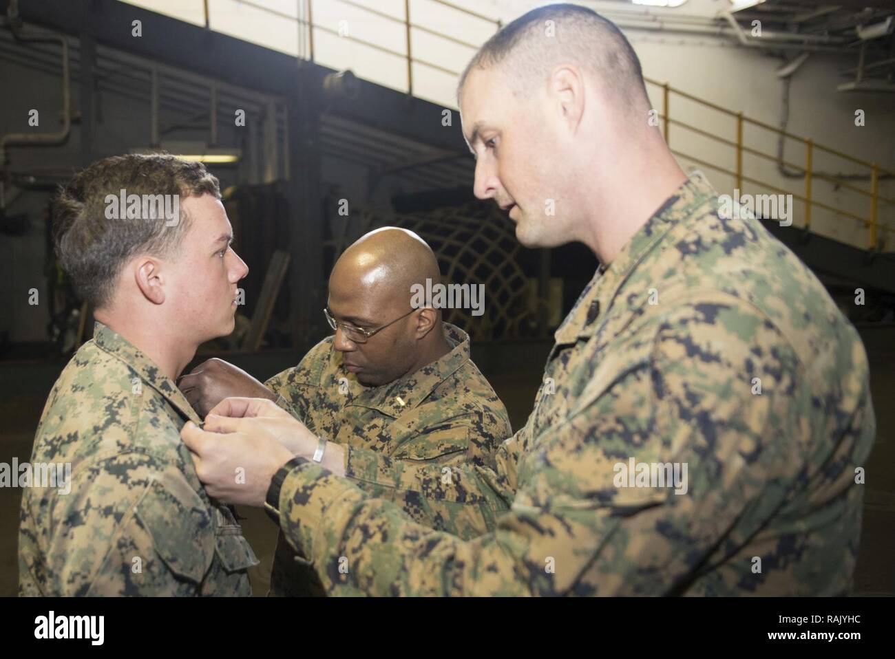 Mer des Philippines (fév. 7, 2017)2 de l'Adjudant-chef Daryle B. Howard, centre, de San Diego, Californie, lutter contre l'agent de fret à bord de navire d'assaut amphibie USS Bonhomme Richard (DG 6), et le sergent d'artillerie. Jason Pringle, droit, de San Diego, Californie, cyber réseau chef affecté à la 31e Marine Expeditionary Unit (MEU), promouvoir le Cpl. Benjamin Tibbetts, un opérateur de réseau cyber bataillon affecté à l'équipe d'atterrissage (BLT), 2/5 de Redmond, Washington, au sergent dans l'équipage du pont du coffre. Bonhomme Richard effectue une formation au niveau de l'unité de combat pour assurer la préparation dans la préparation d'un patro de routine Banque D'Images