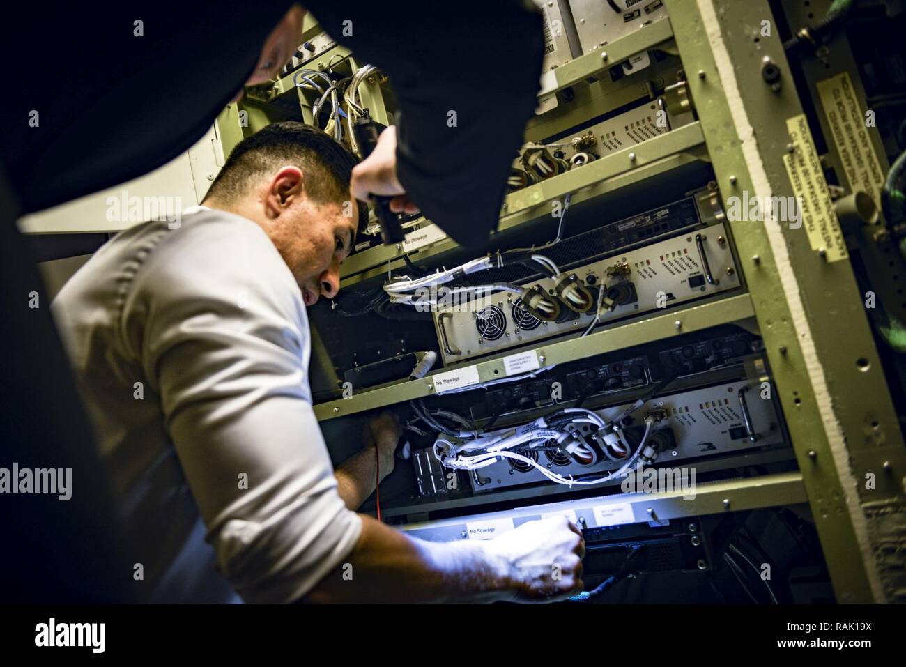 Le s.. Jacob Curtis, 89e Groupe d'entretien chef d'équipage de vol, aide que le plomb, le personnel de FAC Le Sgt. Jesse Sosa, utilise un multimètre pour dépanner un onduleur qui contrôle C-40B communications systems à Joint Base Andrews, dans le Maryland, le 3 février 2017. Les FCC voler sur tous les C-40B et C-32A pour missions le 1er Escadron de transport aérien, et d'effectuer la maintenance sur le terrain ou dans le ciel, et dans ce cas, l'expert de Sosa de dépannage le C-40B Système de communication a permis à ces quatre jours de mission européenne à lancer. Banque D'Images