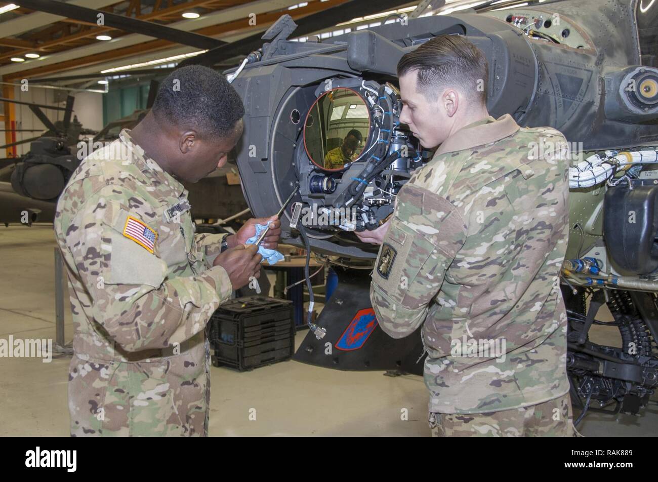 La FPC. Cedric L. Ebrotti et le Sgt. Hunter L. Whirley avec Société Delta 1er Bataillon, 3e Régiment d'aviation d'attaque (Reconnaissance) phase de conduite d'entretien sur un hélicoptère AH-64 Apache à Katterbach Army Airfield, Allemagne, le 10 février 2017. Les inspections de maintenance phase se produire à intervalles réguliers sur tous les aéronefs afin de les maintenir opérationnels. Banque D'Images