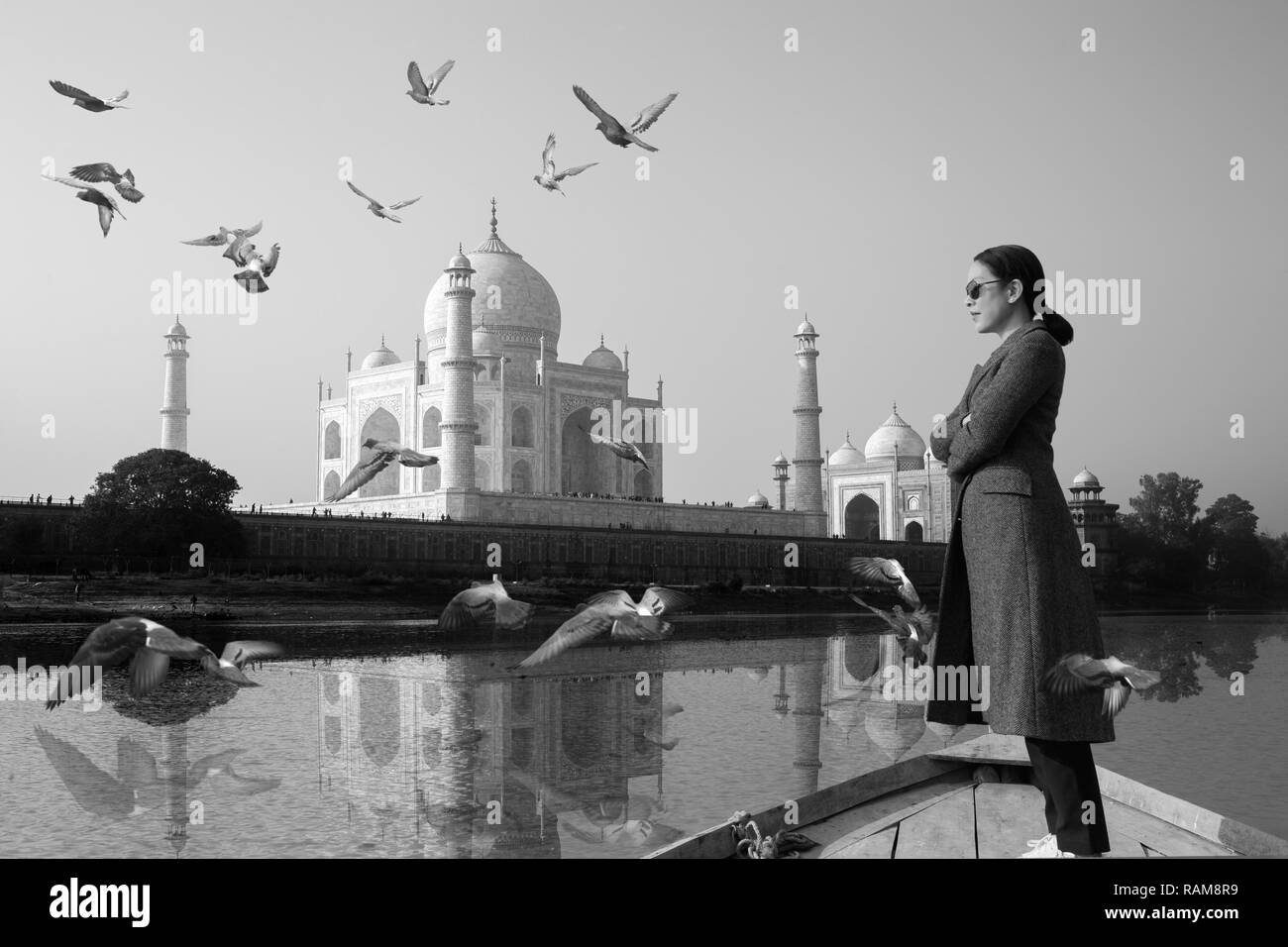 Le port de lunettes de soleil femme debout sur un bateau avec Taj Mahal en arrière-plan. Banque D'Images