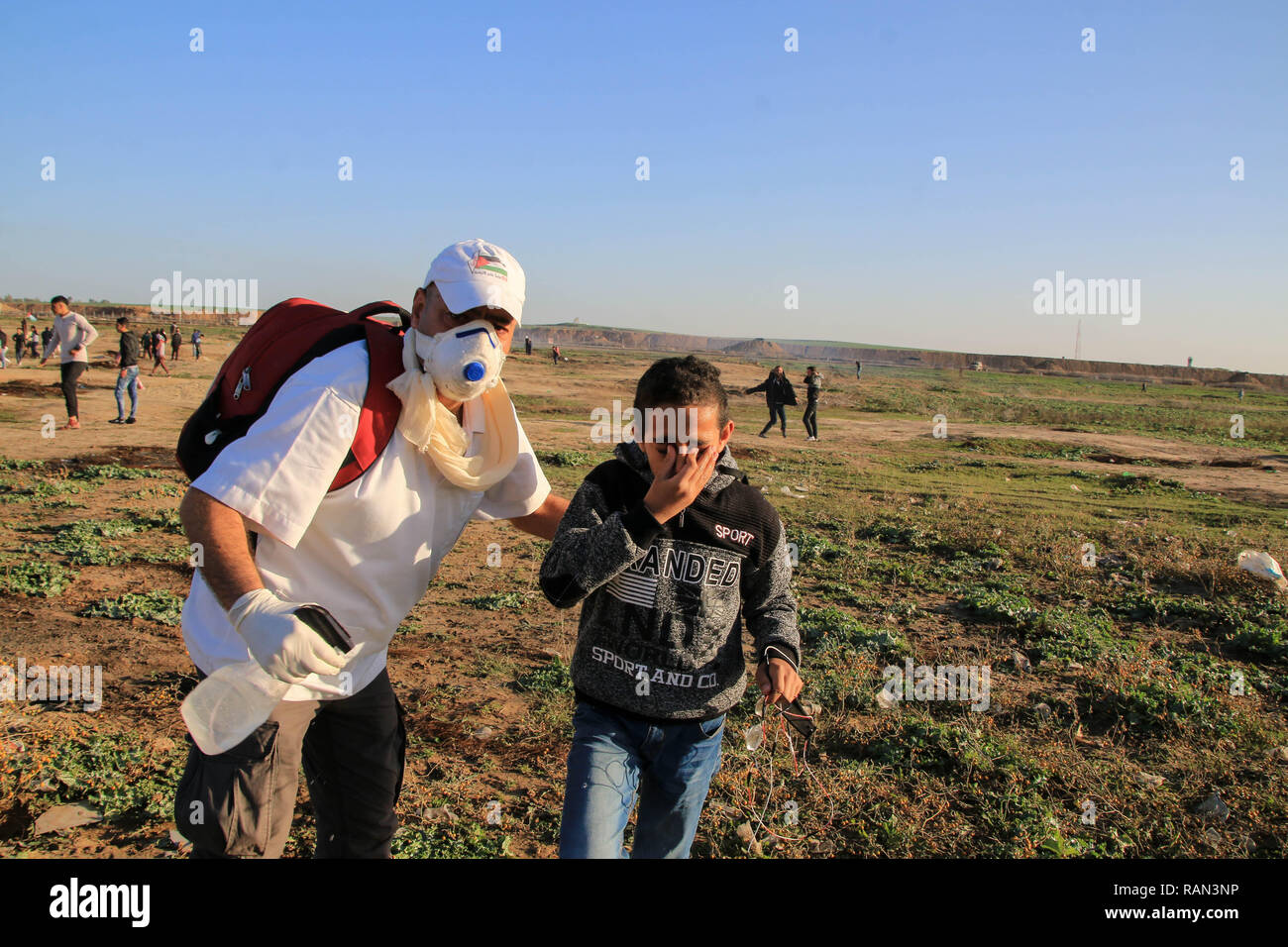 Un infirmier sauvetage d'un enfant blessé lors de démonstrations entre les citoyens palestiniens et les forces israéliennes d'occupation dans une protestation contre la reconnaissance du Président américain Trump Jérusalem comme capitale d'Israël a refusé le blocus de la région nord de la bande de Gaza. Banque D'Images