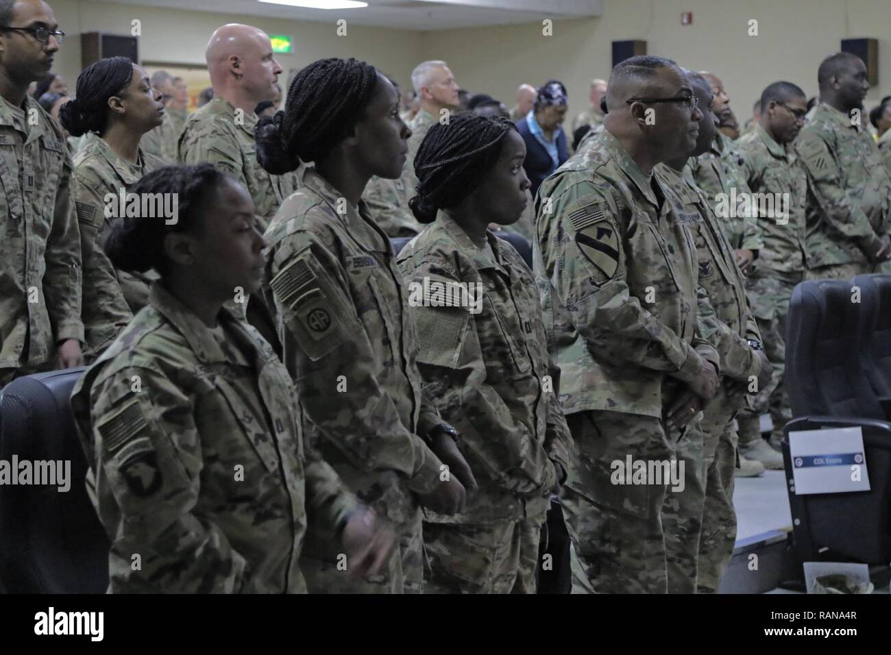 Soldats et civils résidant sur Camp Arifjan écouter intensément à l'invocation au cours de la célébration du Mois de l'histoire des Noirs dans le moral, de loisirs et de bien-être, Théâtre 22 février 2017, Camp Arifjan, au Koweït. La célébration comprenait le colonel conférencier Jeffery Carter, l'actuel vice-commandant de la 316e Commandement de soutien expéditionnaire, et d'un sketch historique appelé "le mois de l'histoire des Noirs. Banque D'Images