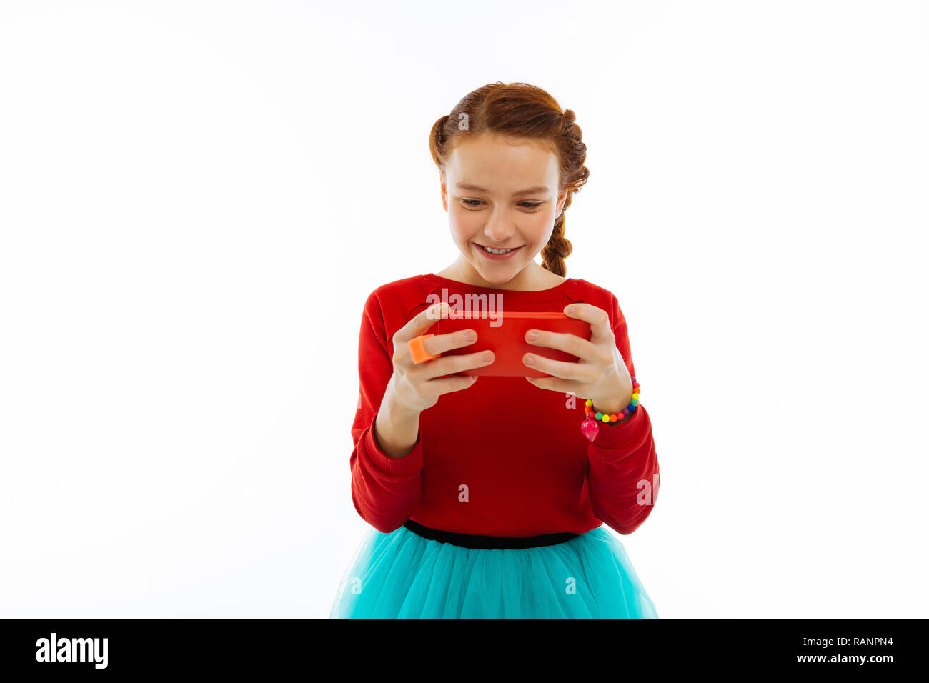 Positive joyeuse fille jouant sur son smartphone Banque D'Images