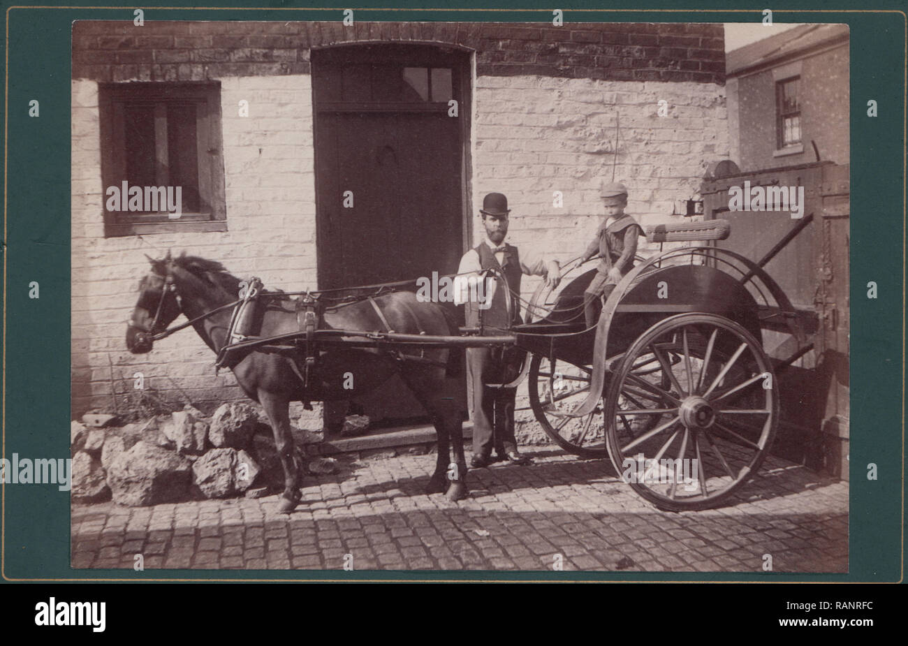 Carte Cabinet victorien montrant un père et son fils avec un cheval et un chariot à l'intérieur d'une cour fermée. Banque D'Images