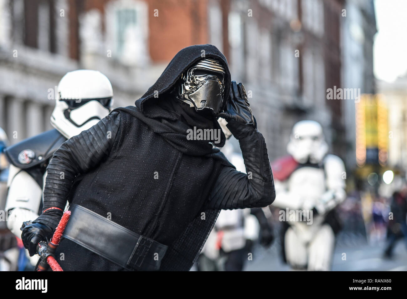 Kylo Ren costume de personnage dans le films de Star Wars au London's New Year's Day Parade, au Royaume-Uni. L'écoute, l'oreille en cornet, de huées de la foule Banque D'Images