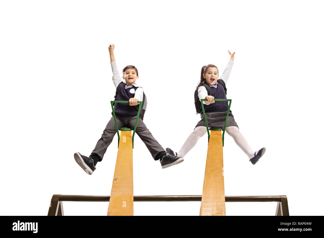 Tourné sur toute la longueur d'un écolier et lycéenne en uniforme jouant sur une balançoire isolé sur fond blanc Banque D'Images