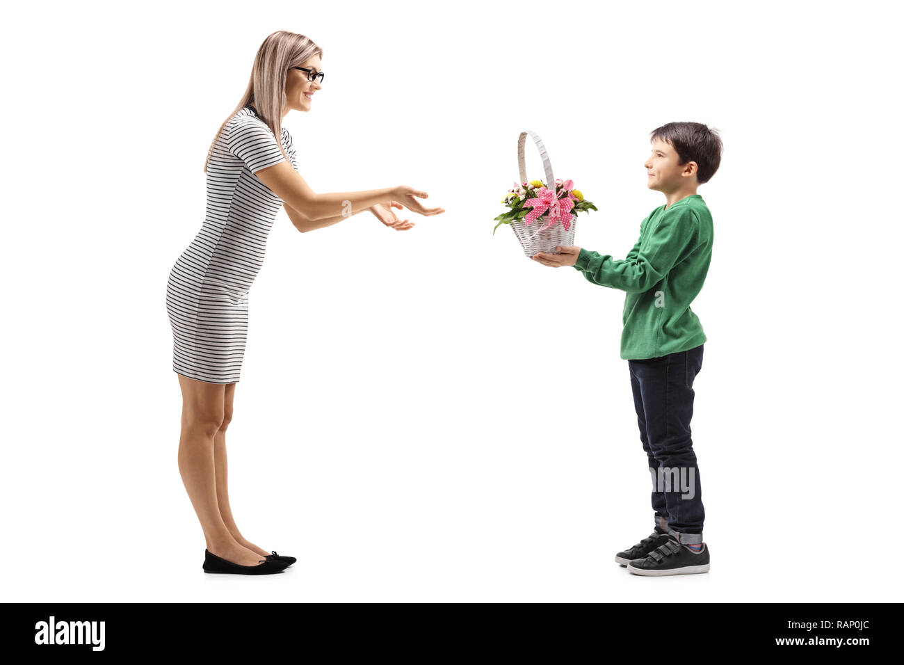 Tourné sur toute la longueur d'un jeune garçon donnant des fleurs à sa mère isolé sur fond blanc Banque D'Images