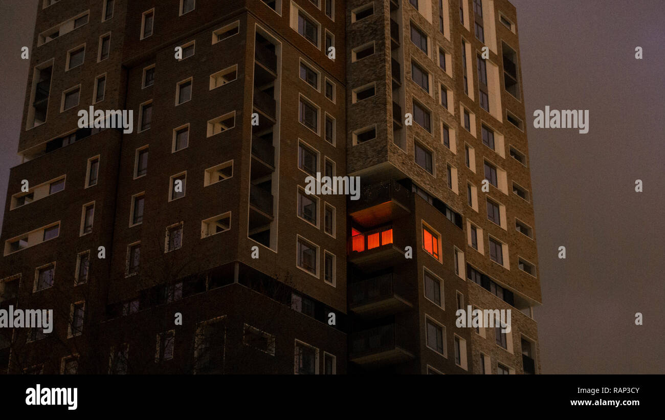 Une fenêtre est illumionated orange dans un bloc d'appartements dans la région de Camberwell, Londres, Angleterre, Royaume-Uni. Banque D'Images