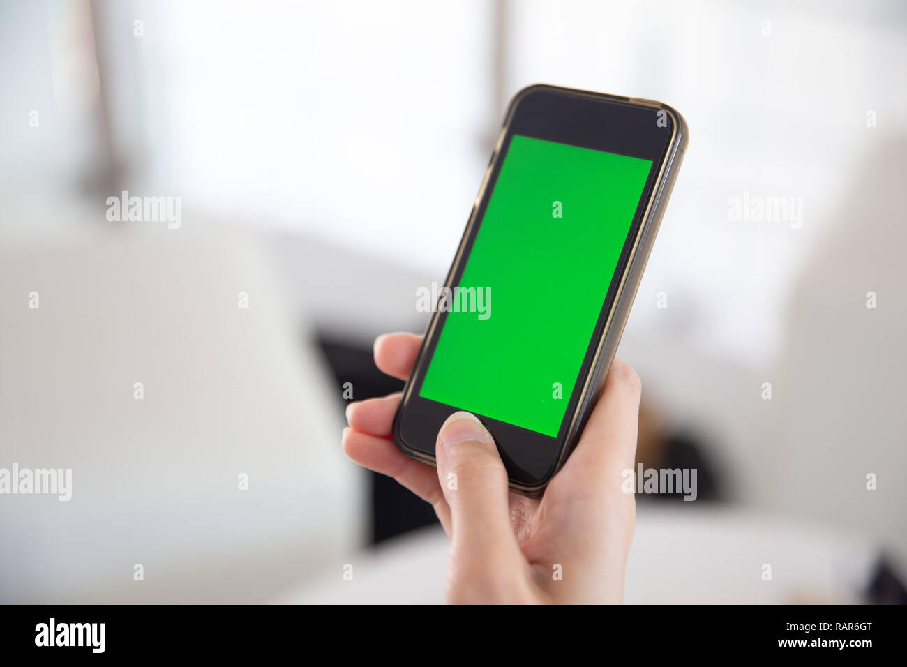Main libre Smartphone avec écran tactile vert isolé. Banque D'Images