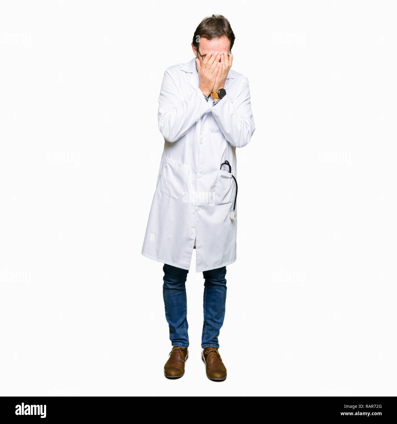 L'âge moyen des hommes en manteau médical médecin avec expression triste couvrant le visage avec les mains en pleurant. Concept de dépression. Banque D'Images