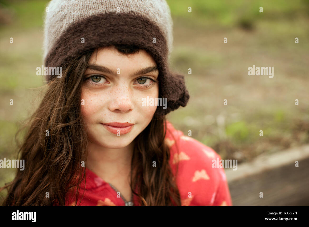 Jeune fille portant un chapeau en tricot pose pour un portrait. Banque D'Images