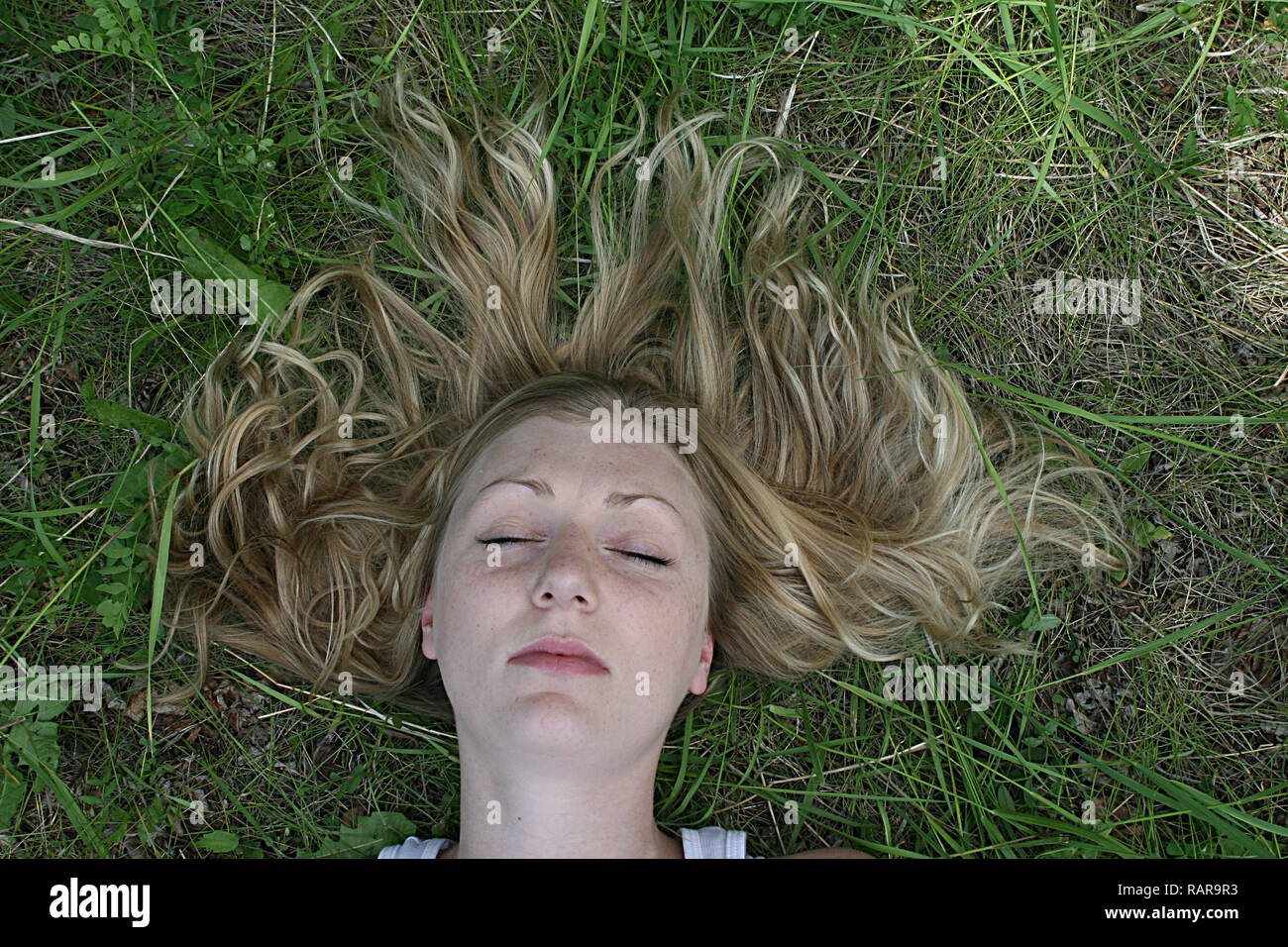 Femme allongée sur le dos dans l'herbe. Banque D'Images