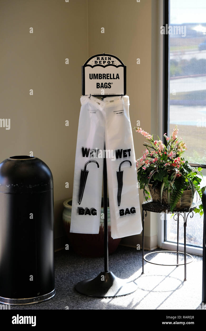 Distributeur de sacs parapluie mouillé ; sacs en plastique pour les parapluies dans un immeuble de bureaux hall. Banque D'Images