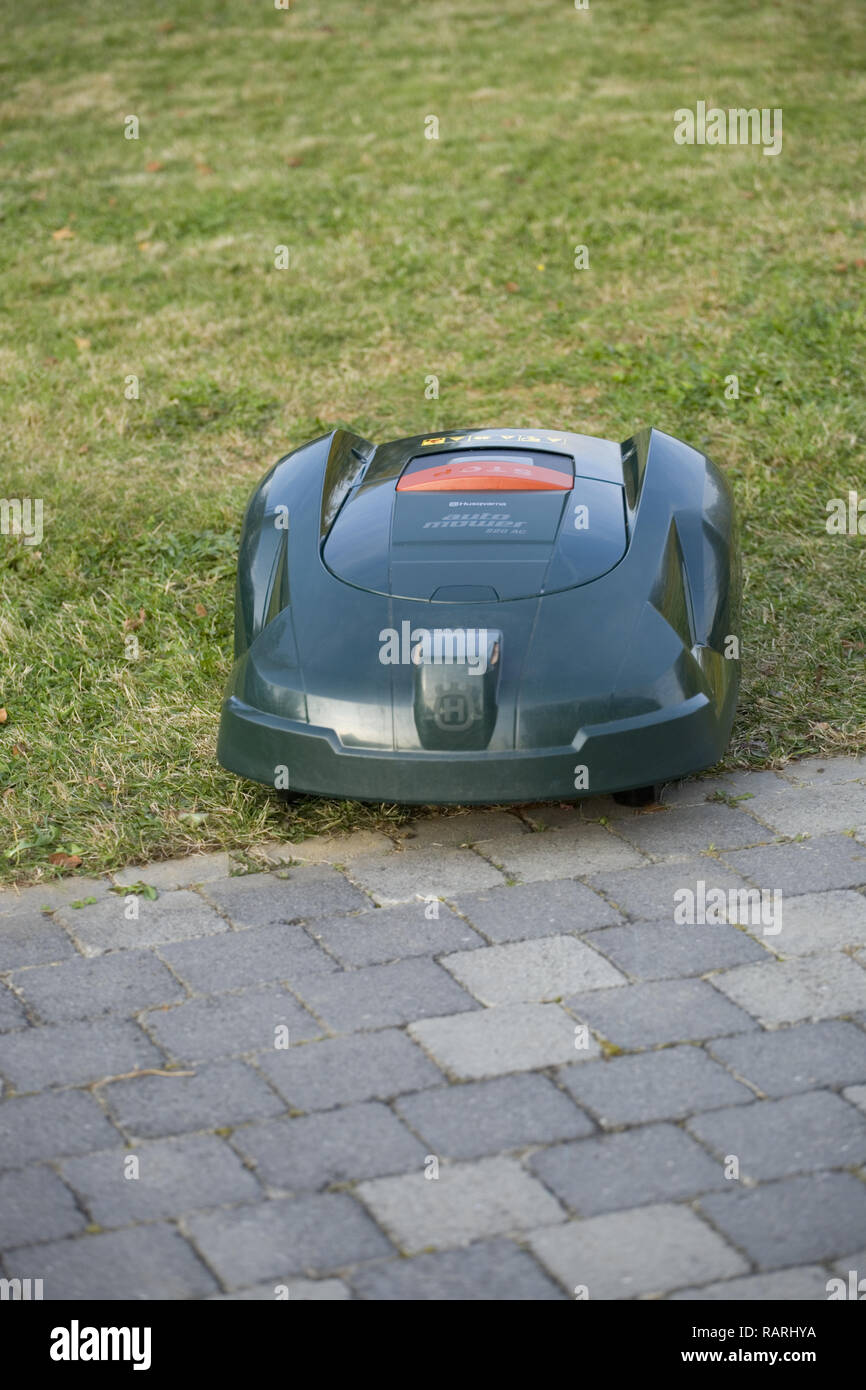 Tondeuse robot automatique coupé de l'herbe à côté patio Banque D'Images