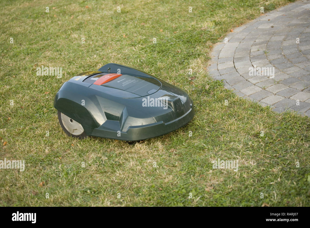 Tondeuse robot automatique coupé de l'herbe près d'un patio Banque D'Images