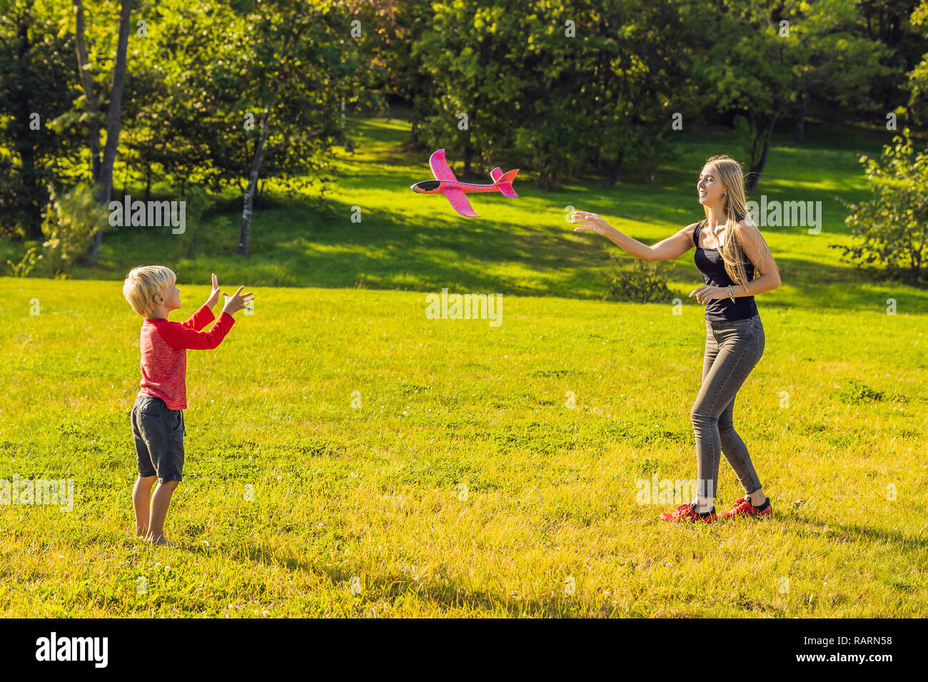 Mère et fils jouant avec un grand modèle toy airplane dans le parc Banque D'Images