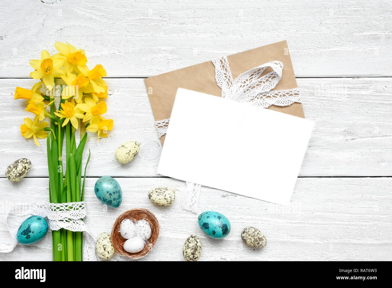 Carte de vœux de pâques avec les oeufs de Pâques et de fleurs de printemps sur la maquette en bois blanc table. vue d'en haut. télévision lay Banque D'Images