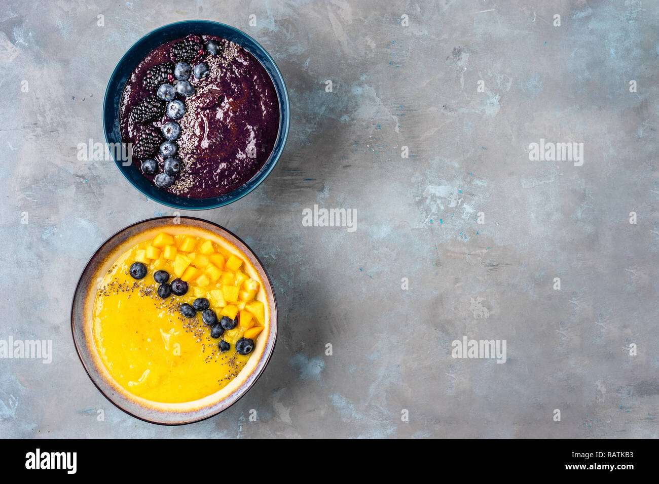 Vue de dessus de deux plaques avec jaune et violet smoothies Banque D'Images