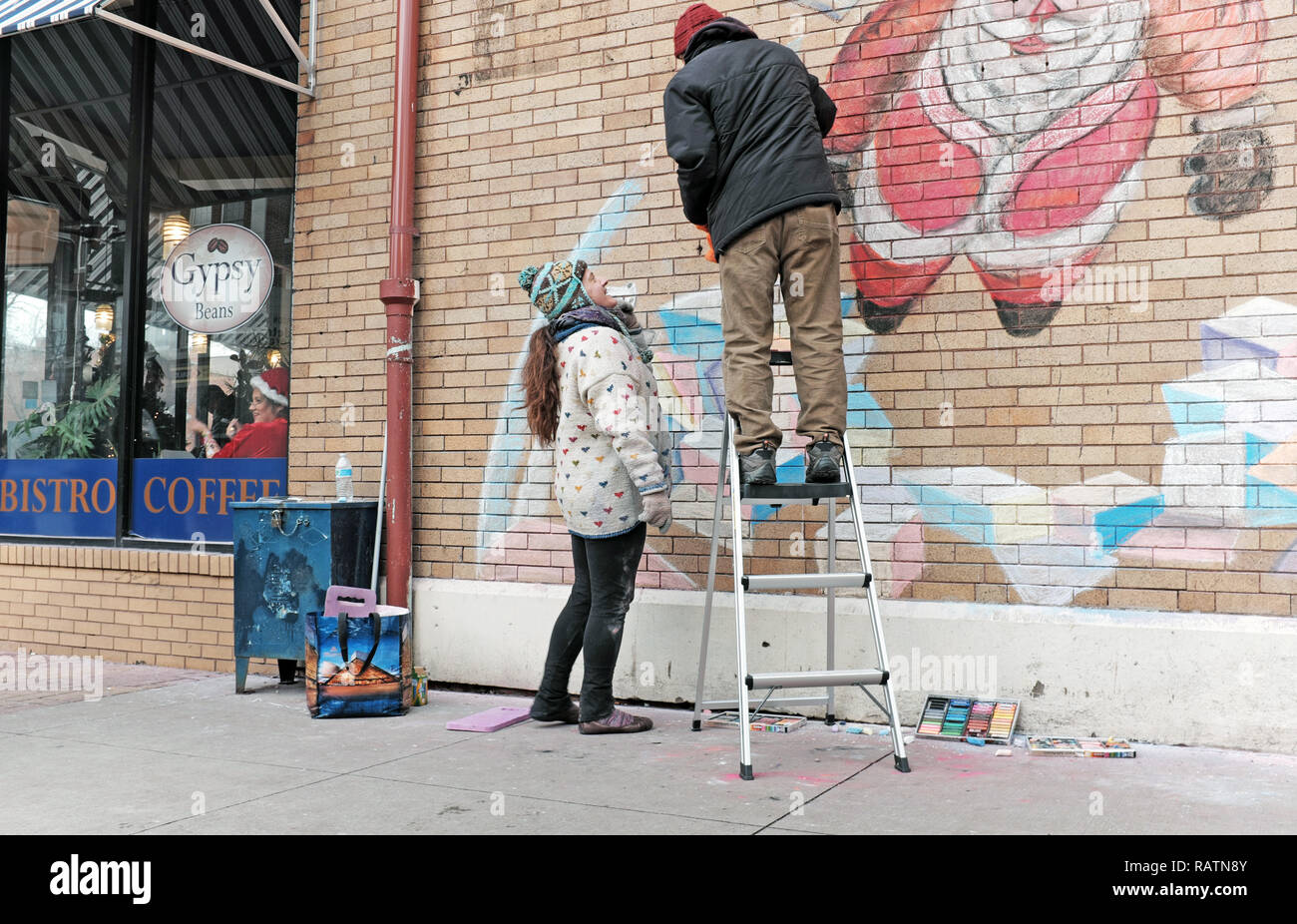 Deux artistes utilisent la craie pour créer une fresque temporaire de vacances sur le côté du Gypsy Bean sur East 65th Street, Gordon Square, Cleveland, Ohio, USA. Banque D'Images