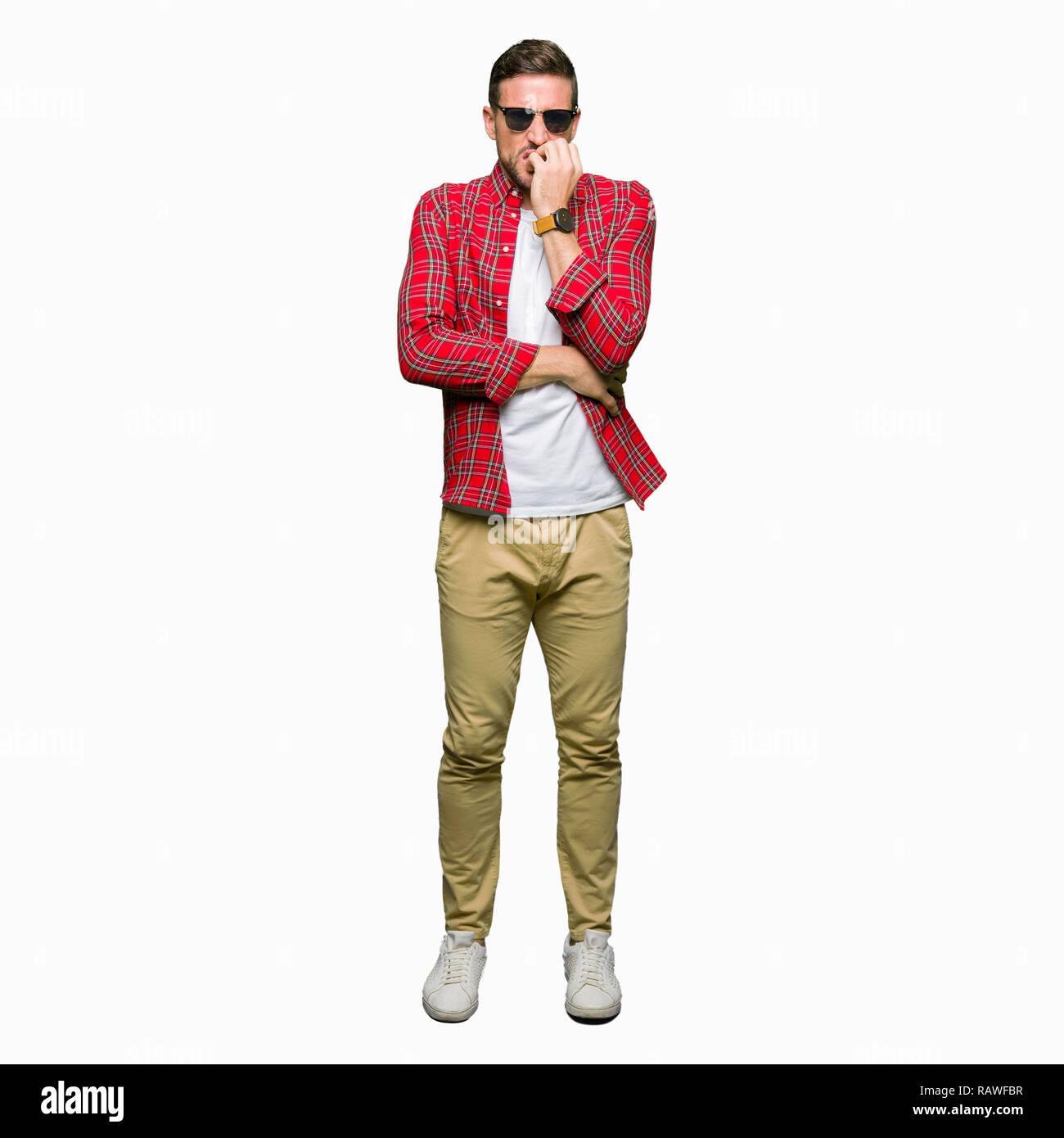 Bel homme portant des lunettes de soleil à la mode a souligné et nerveux avec les mains sur la bouche de mordre les ongles. Problème d'anxiété. Banque D'Images