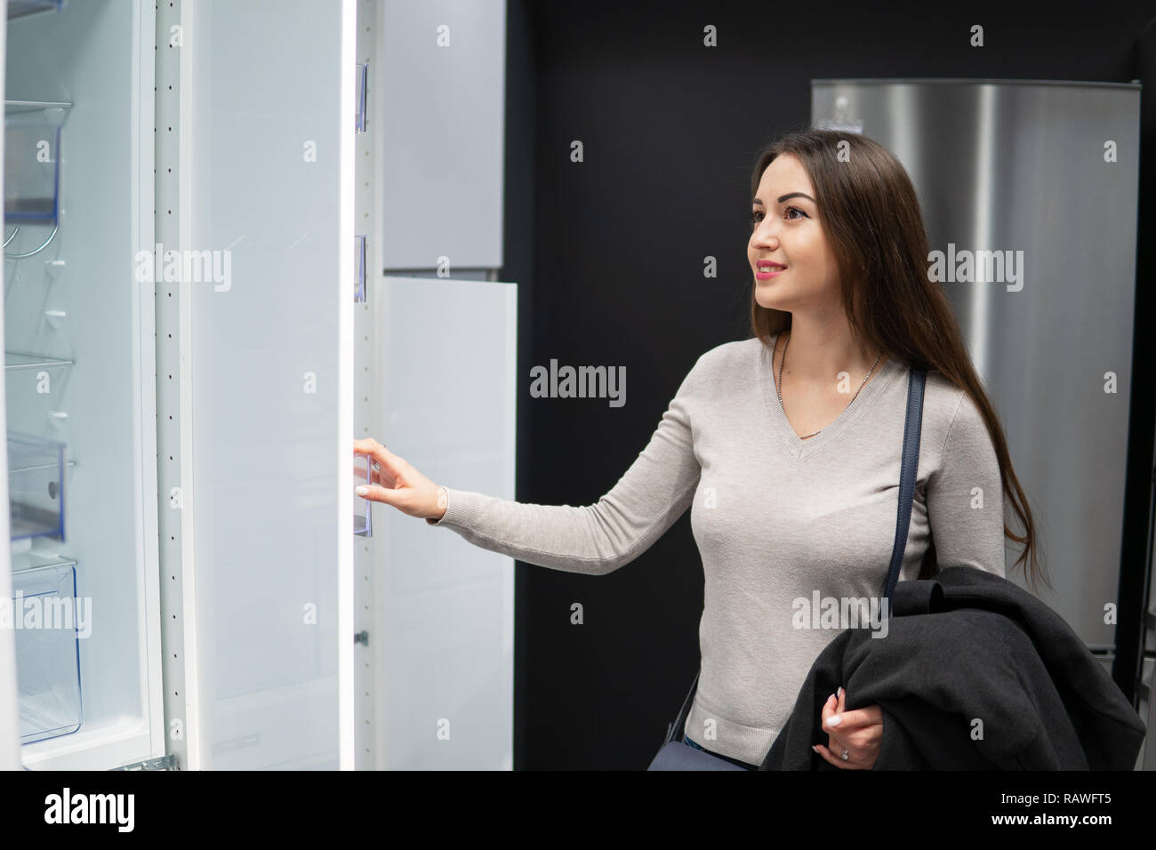 Belle jeune femme se trouvant de nouveaux meubles, armoire Banque D'Images