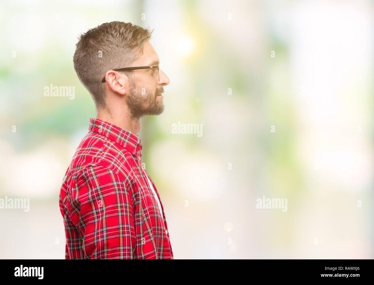 Jeune homme séduisant sur fond isolé à côté de beauté, posent avec profil visage naturel avec sourire confiant. Banque D'Images