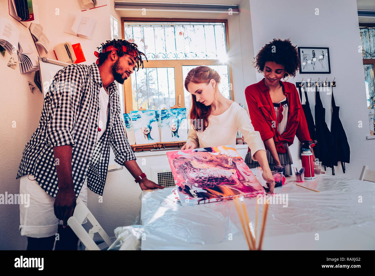 Red-haired female artist holding belle grande photo couleur Banque D'Images
