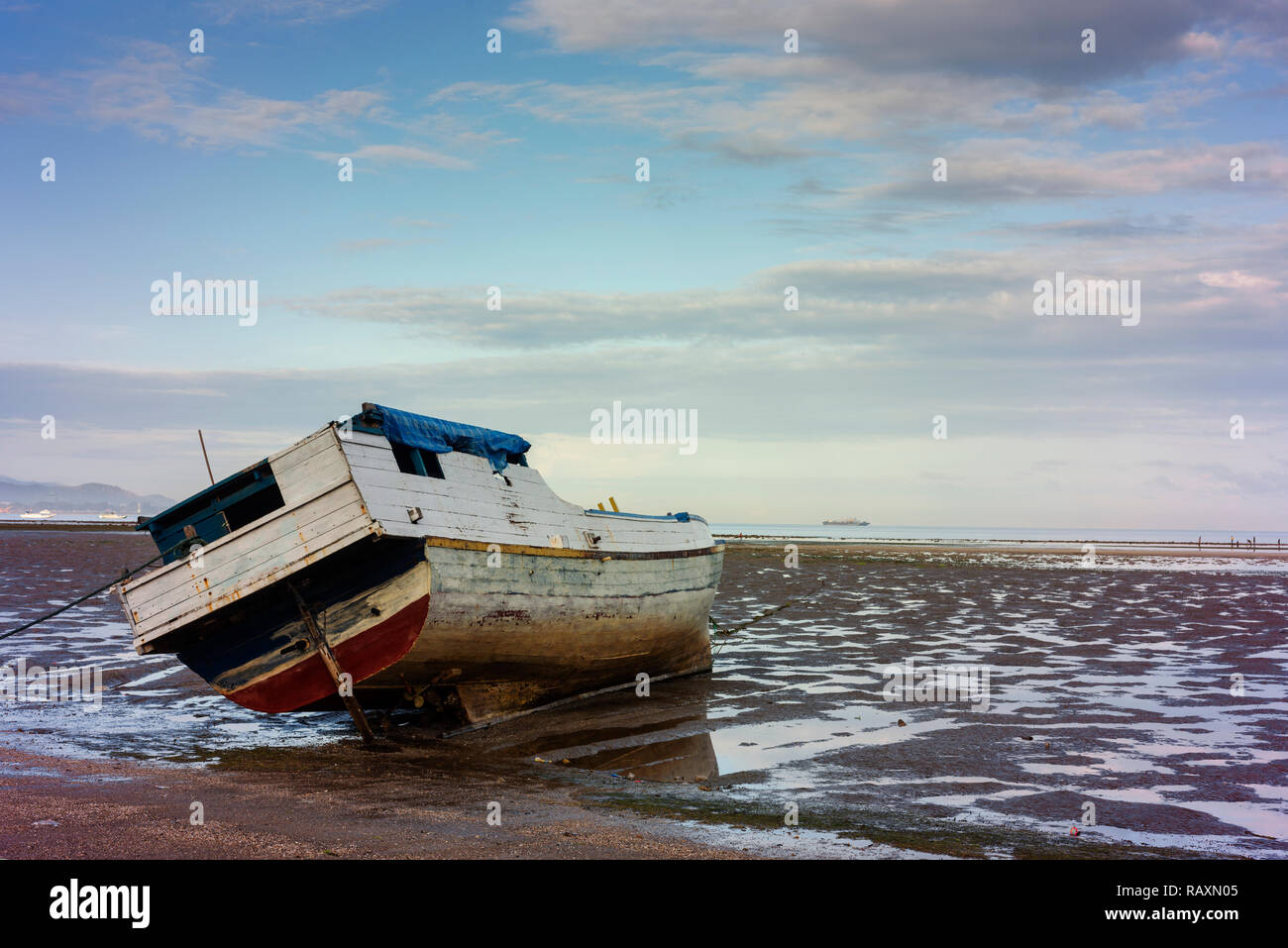 Un bateau traditionnel se trouve sur le sable à marée basse à Dili. Banque D'Images