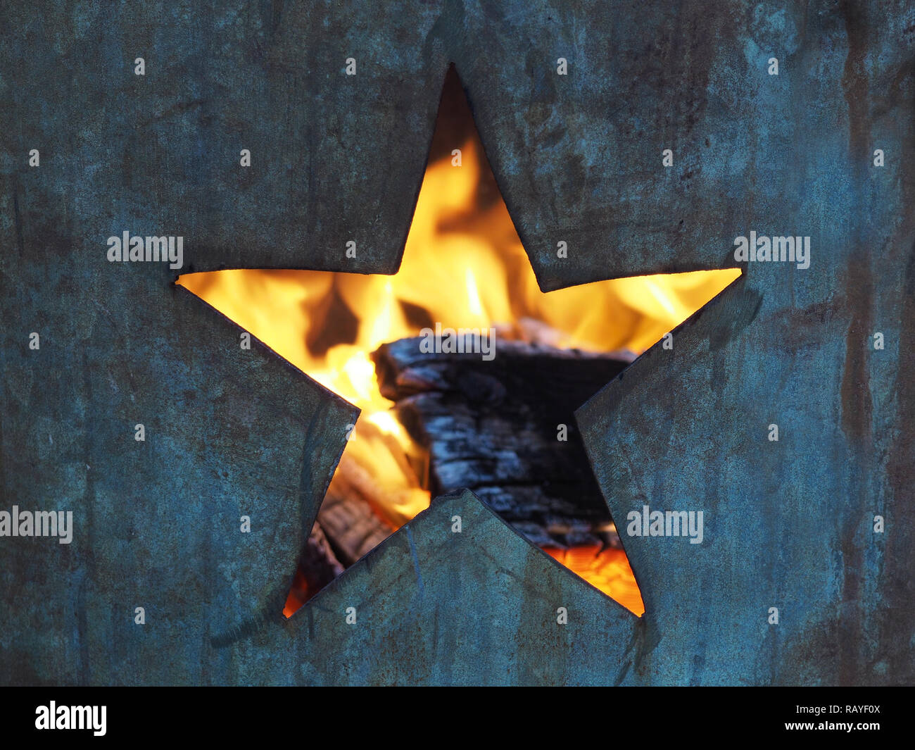 Trou dans la forme d'une étoile à cinq branches coupées en un metal burning canon à flammes et visibles à l'intérieur du bois brûlé Banque D'Images
