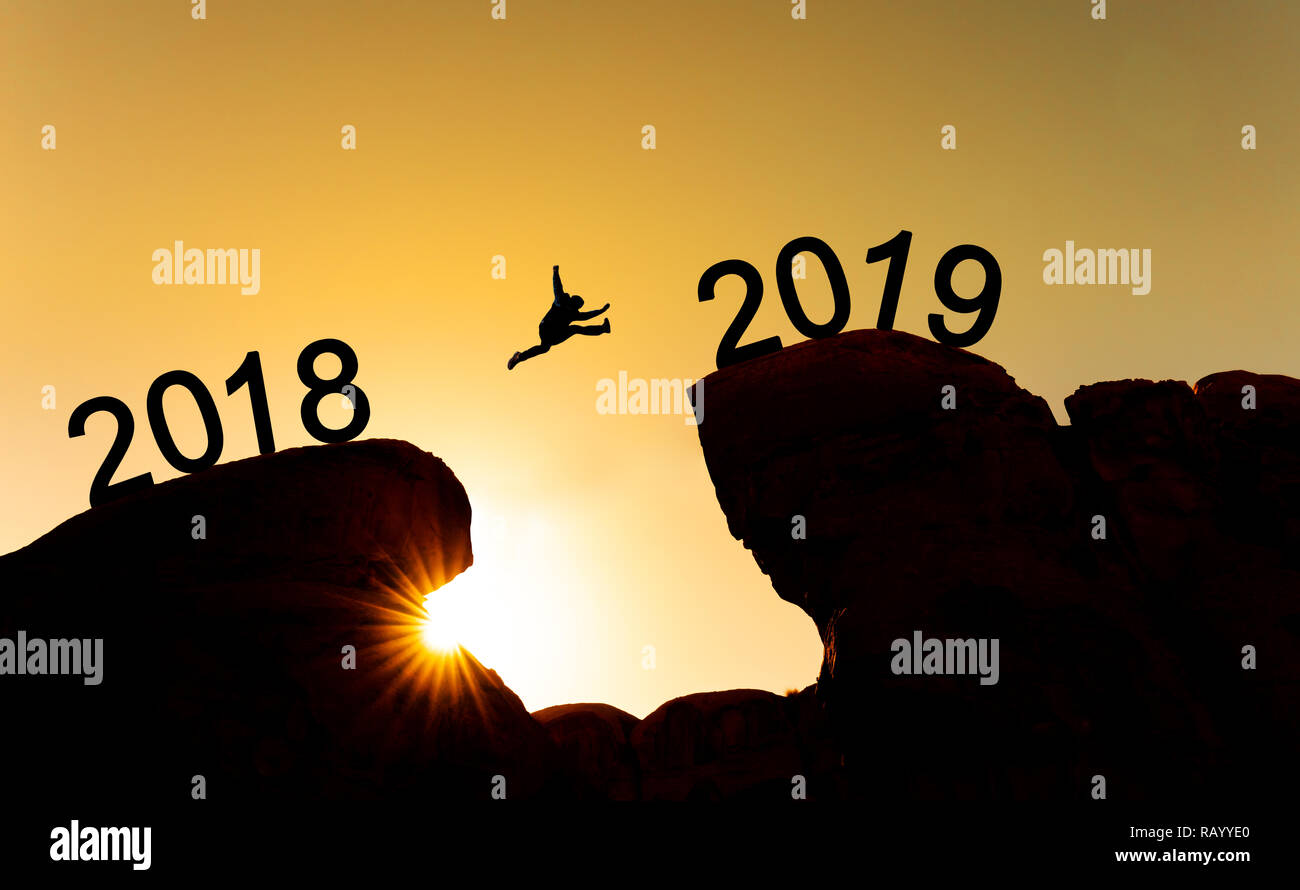 Nouveau concept de l'année, la silhouette d'un homme sautant sur falaise de 2018 à 2019 Banque D'Images