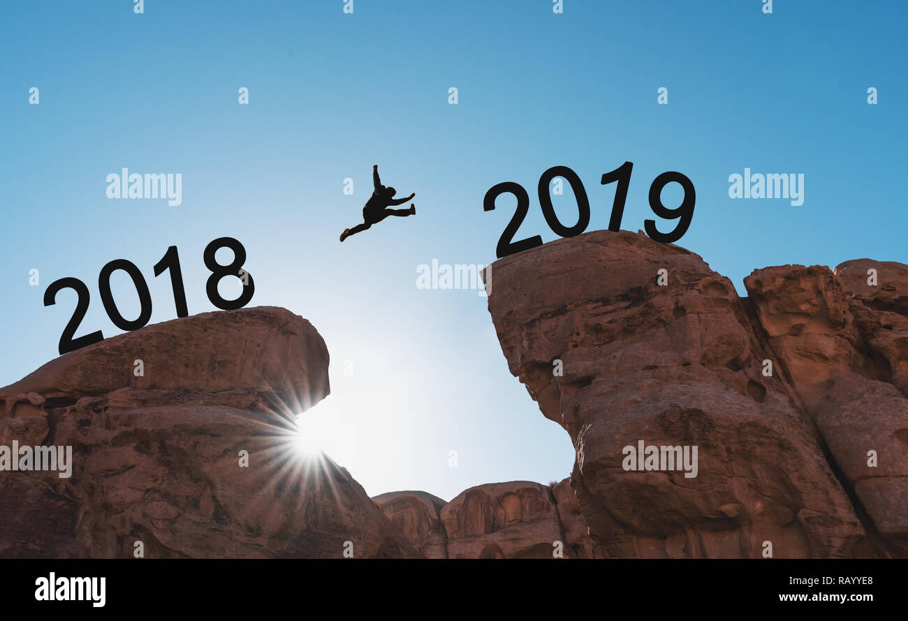 Nouveau concept de l'année, la silhouette d'un homme sautant sur falaise de 2018 à 2019 Banque D'Images