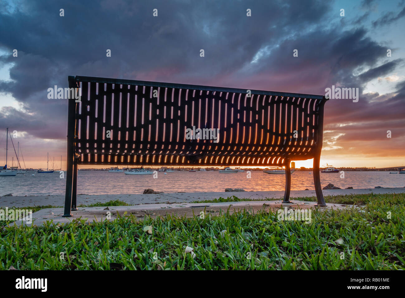 Banc de parc isolé dans un parc public au coucher du soleil à Sarasota, Floride avec ciel dramatique Banque D'Images