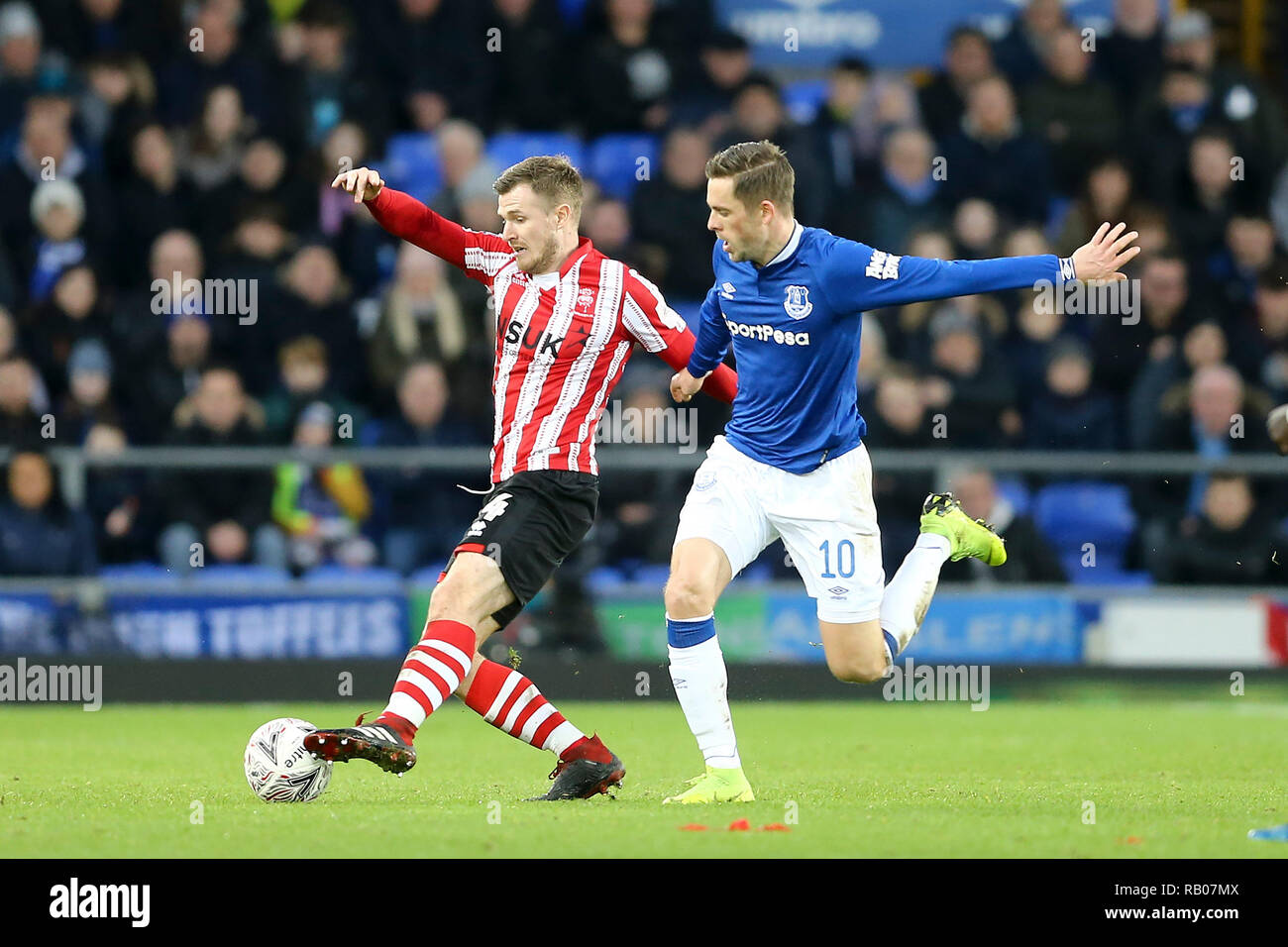 Liverpool, Royaume-Uni. 5e jan 2019. Michael O'Connor de Lincoln City (l) protège la balle de Gylfi Sigurdsson d'Everton. L'unis en FA Cup, 3ème tour, Everton v Lincoln City à Goodison Park à Liverpool le samedi 5 janvier 2019. Ce droit ne peut être utilisé qu'à des fins rédactionnelles. Usage éditorial uniquement, licence requise pour un usage commercial. Aucune utilisation de pari, de jeux ou d'un seul club/ligue/dvd publications. Photos par Chris Stading/Andrew Orchard la photographie de sport/Alamy live news Banque D'Images