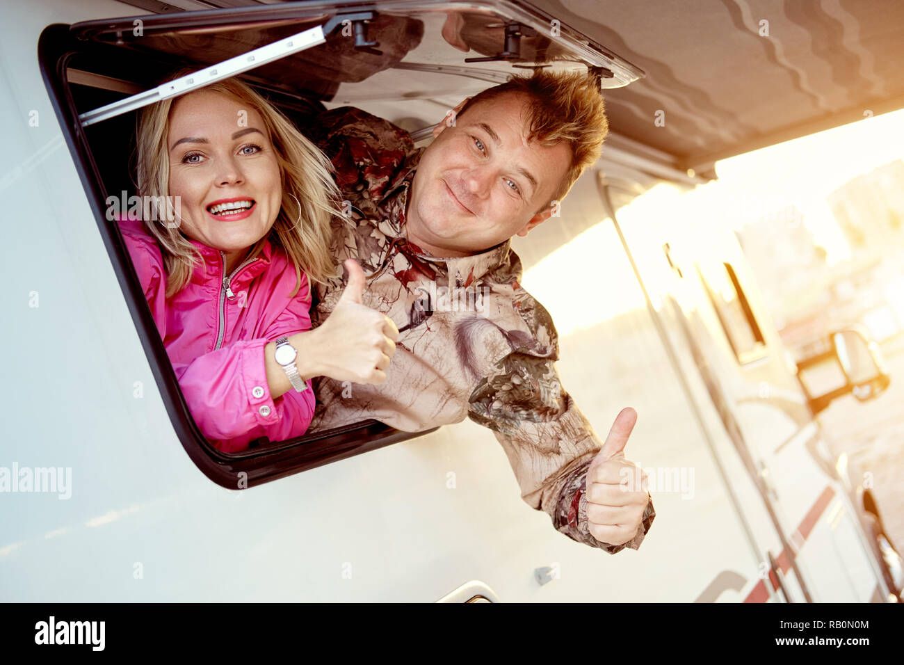 Couple mariés spectacle familial coup de doigt de haut en sortant du véhicule de loisir caravane autocaravane fenêtre remorque looking at camera Banque D'Images