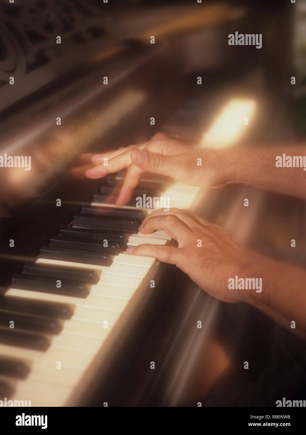 L'homme participe activement à jouer du piano avec un effet de filtre pour souligner l'appuyant sur des touches de piano en temps réel Banque D'Images