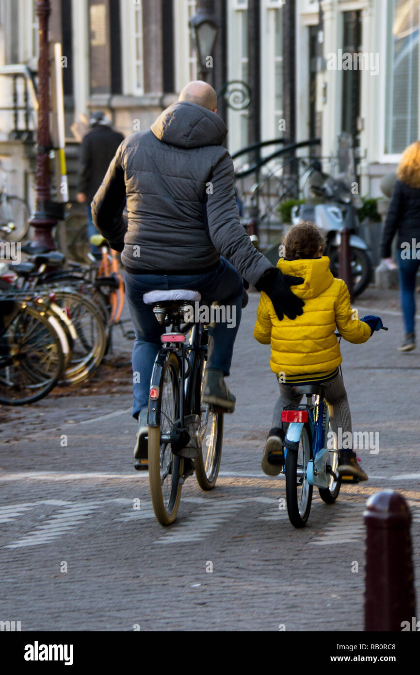 Un homme et son riding leurs vélos ensemble à Amsterdam Banque D'Images