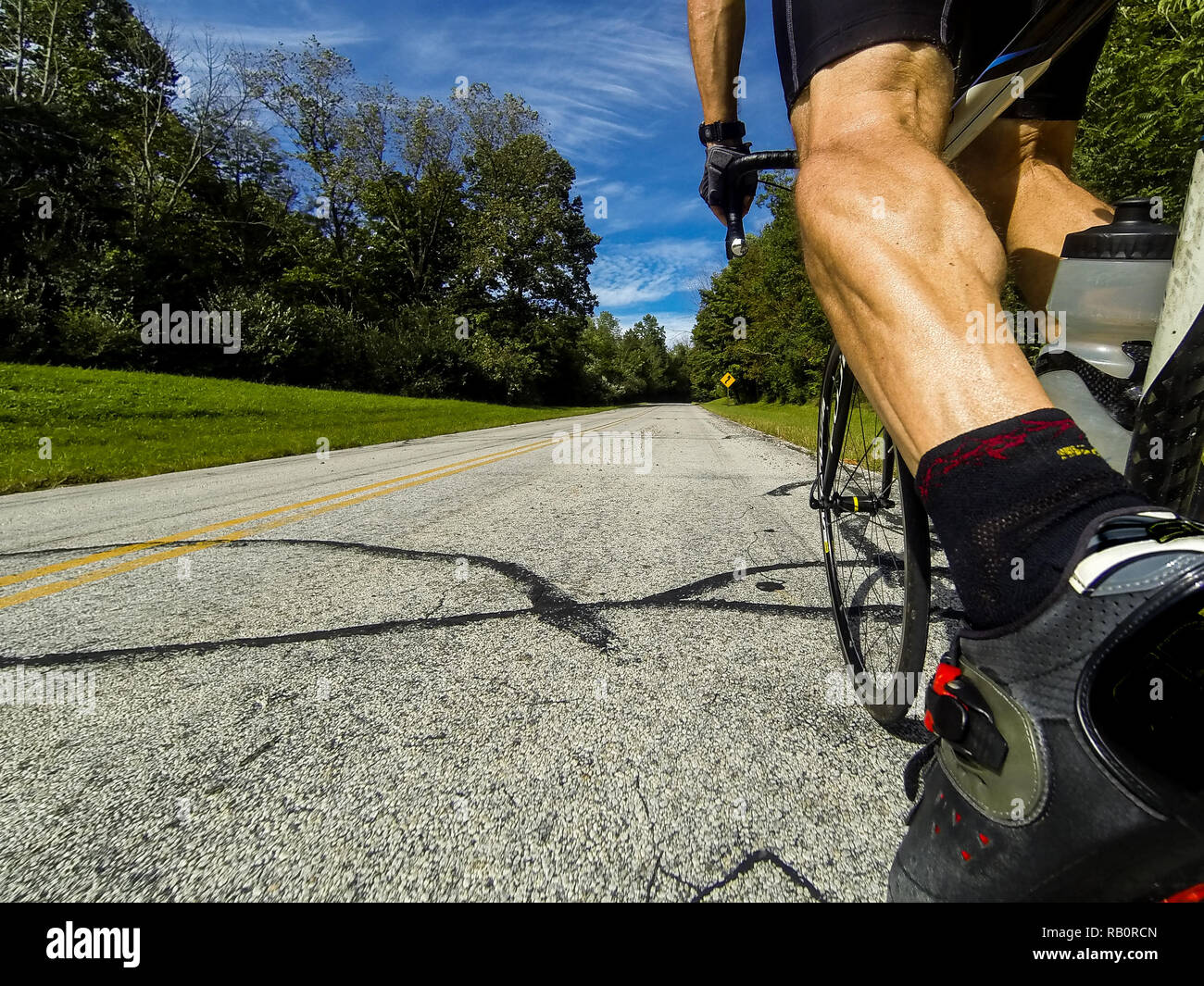 Un cycliste homme équitation en haut d'une colline, sur une route en Ohio sur un vélo de course le matin DCIM101GOPRO Banque D'Images