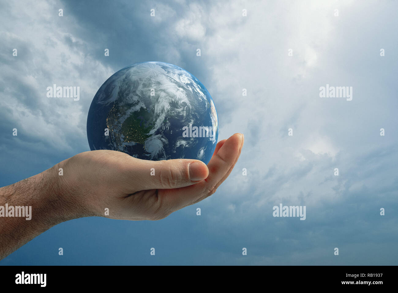 Globe dans la main de l'homme contre le ciel bleu. Concept de protection de l'environnement. Banque D'Images
