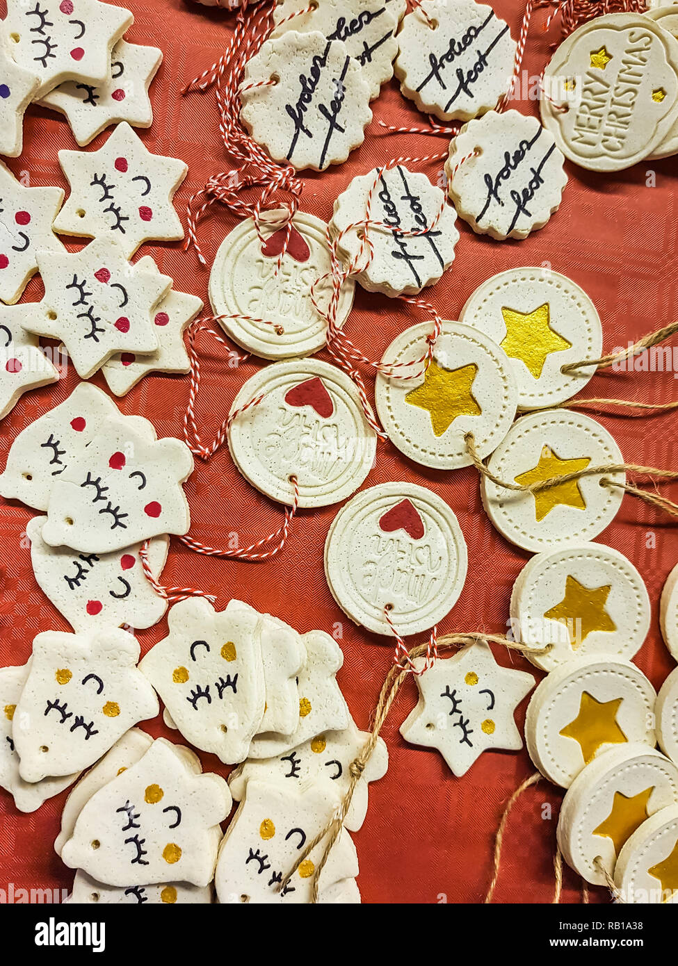 Collection de décorations de Noël avec cintres dispersées sur un fond rouge avec des cloches et des disques avec des coeurs, des étoiles et de voeux Banque D'Images