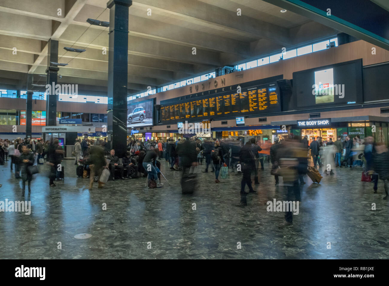 Passagers à London Euston, Londres, Angleterre sur les trains en attente d'Hall Banque D'Images