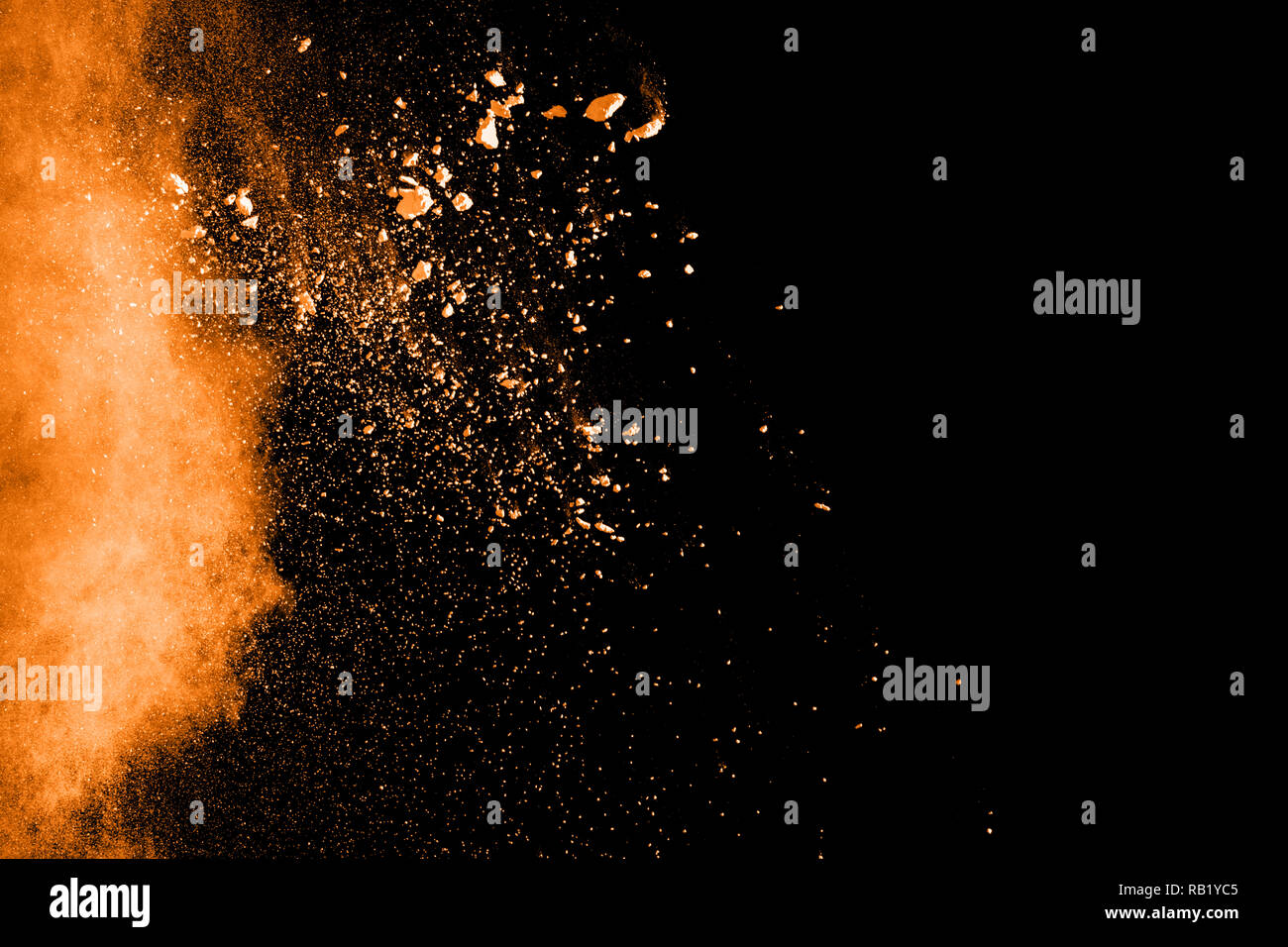 Abstract explosion de poussière orange sur fond noir. Motion de gel poudre orange aux éclaboussures. Banque D'Images
